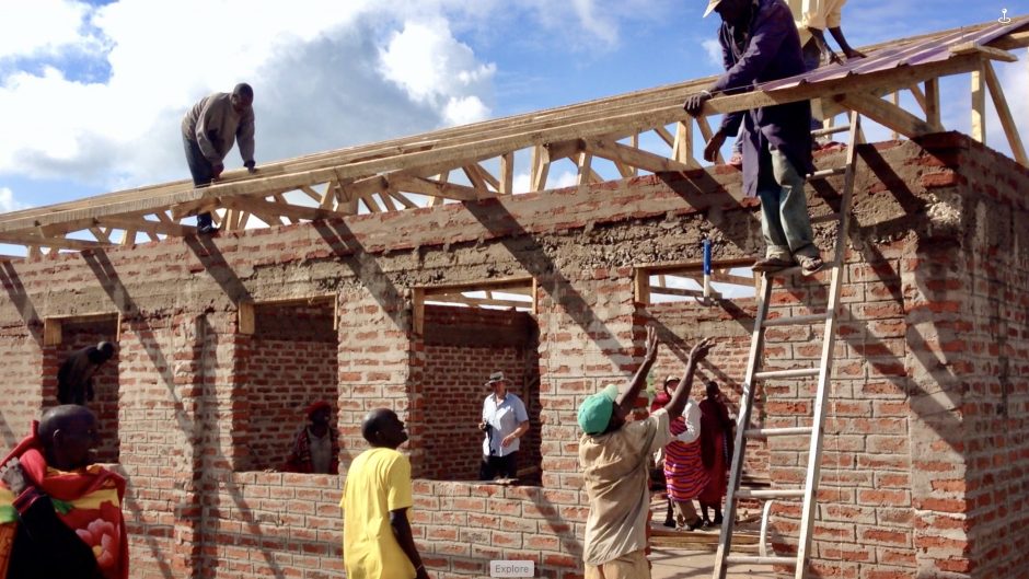 The community at work on the first classroom building.